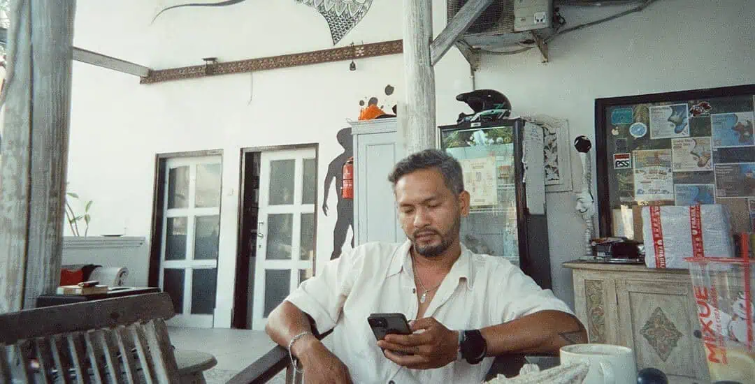 Man using smartphone at Bali Center Dive, Nusa Penida diving spot.