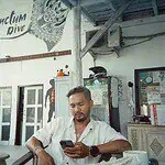 Man using smartphone at Bali Center Dive, Nusa Penida diving spot.