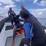Group of divers preparing for Bali diving in Nusa Penida with clear blue skies.